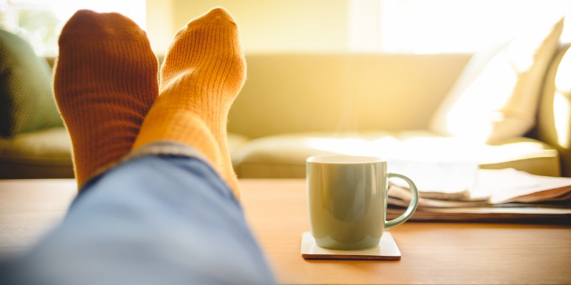 Feet on table with cup of coffee