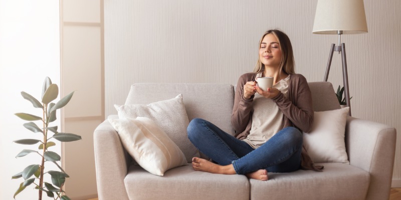 Women relaxing on sofa with cup of coffee